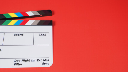 Clapper board or movie slate on red background.it use in video production and film industry .