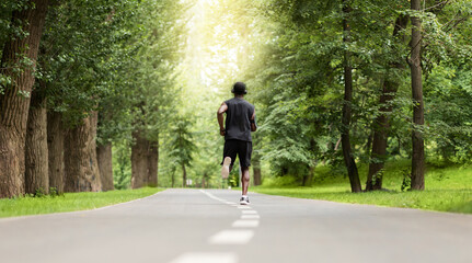 Rear view of black jogger exercising at park