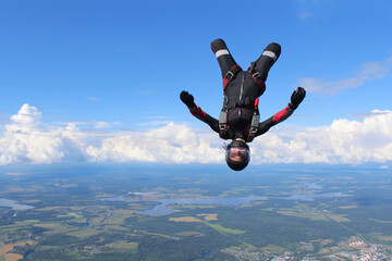 Skydiving. A young woman is flying in the sky in head down position.