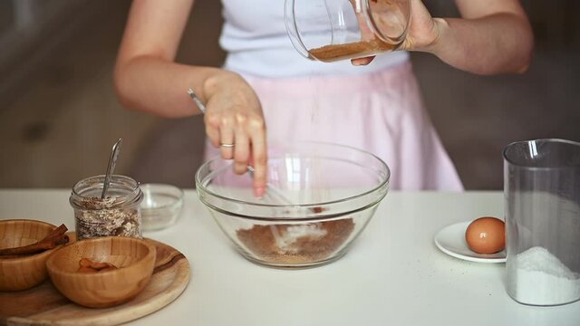 Woman preparing cookies at the kitchen, mixing flour, and brown coconut sugar
