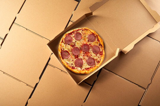 Open takeaway box with Italian salami pizza