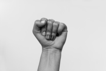 Protest. Blurred image of female fist protesting, black and white photo. Female hand raised up, strong and power concept. Women rights fight. Stop racism