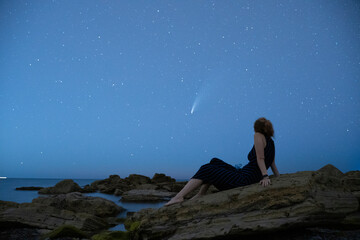 woman looking at neowise comet at night