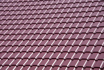 Roof of a house with modern red metal roof tiles