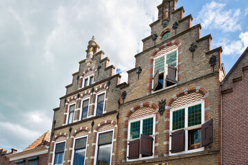 Fototapeta na wymiar Detailed view of classic dutch canal houses with traditional blinds or shutters in the historic town of Oudewater, Holland