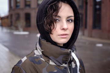 Fototapeta premium Stylish brunette woman in trendy apparel looking and enjoying winter in city.