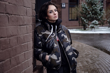 Fototapeta na wymiar Stylish brunette woman in trendy apparel looking and enjoying winter in city.