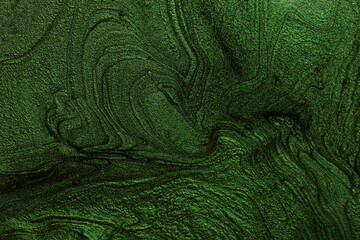 Green liquid nail polish,abstract banner with copy space.Makeup concept.Creativewave of liquid nail laquer.Modern background.Pour painting art work.Macro photography.Fluid art technique.