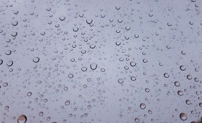 Beautiful photography of the waterdrop over the window. Indoor panoramic view to the city after rain.