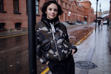 Stylish brunette woman in trendy apparel looking and enjoying winter in city.