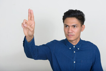 Portrait of handsome Asian businessman touching something