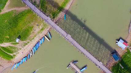 Aerial top view of Wooden bridge with tour boat in Thailand