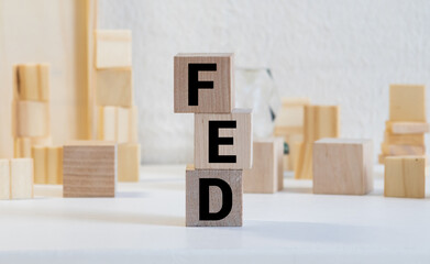 FED, Federal Reserve concept, cube wooden block with alphabet building the word FED at the center on dark blackboard background, the institution to control US financial banking.