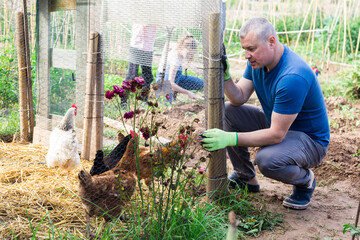 Positive farmer builds chicken coop fence on farm © JackF