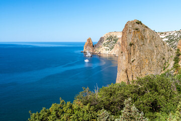 Fototapeta premium View from above on the coast of Fiolent, in the bay can be seen a rock in the sea and Inflatable round plateun fon holiday by the sea.