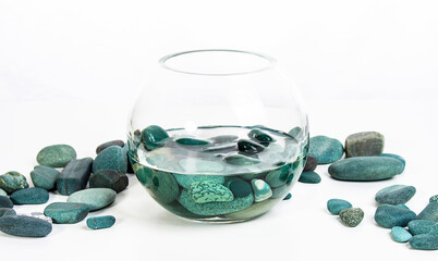 sea stones turquoise in water in a glass vase on a white background