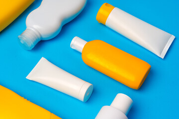 Bottles of sunscreen cream on blue background