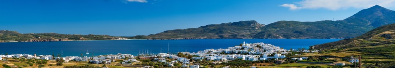 Fototapeta na wymiar View of Plaka village with traditional Greek church and white painted houses and ocean coast. Milos island, Greece