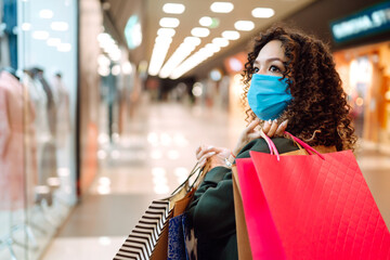 Young woman in medical face mask after shopping during coronavirus pandemic. Covid-2019.