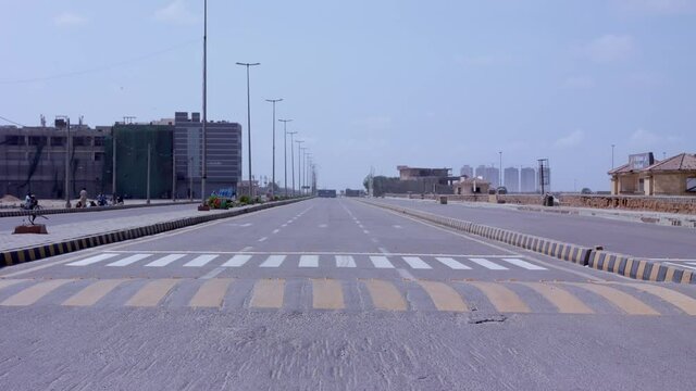 Empty road in Karachi during the lockdown as one pickup carries water bottles to supply to households during curfew in the country. 