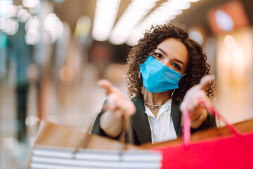Obraz na płótnie Canvas Young woman in medical face mask after shopping during coronavirus pandemic. Covid-2019.