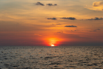 Fototapeta premium Sunset on the island of Phu Quoc, Vietnam. Travel and nature concept. Evening sky, clouds, sun and sea water