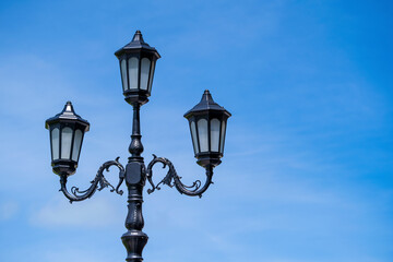 Fototapeta na wymiar Retro street lamppost against the blue sky background, closeup, copy space
