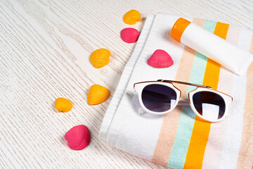 Beach accessories with sea shells on wooden background