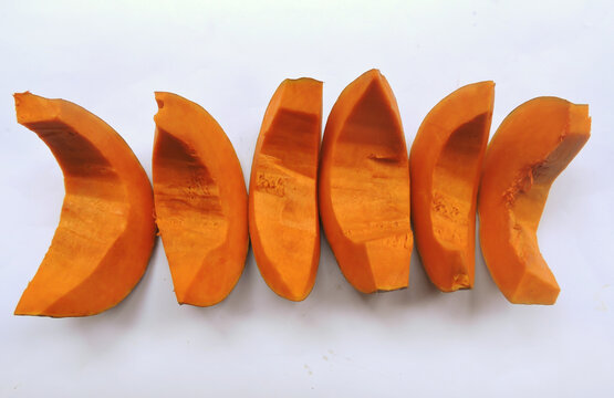 Bright orange colored pieces of fleshy pumpkin shell. 