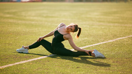 girl in black sport outfit doing doing gymnastics in the splits © Bogdan