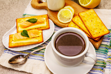 Healthy breakfast. Cup of coffee (black tea), milk, crackers with butter and salmon
