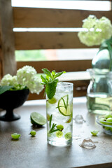 Glass of cold refreshing summer drink with berries and ice cubes on table close up