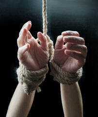 Hands of a victim woman tied up with rough rope. Stop abusing violence concept