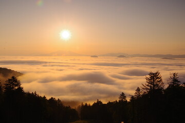 大地を覆う雲を照らす朝陽。津別峠、北海道、日本。