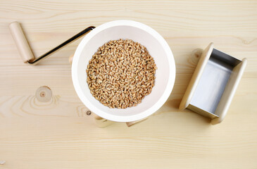 A small grain grinder on a wooden background. Traditional wheat and grain grinder used to grind grain and make flour of wheat and rice. Czech Republic, Europe.