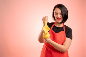 Woman employed at supermarket with red apron and black t-shirt squeeze a lemon