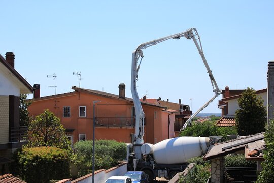 Rome, Italy-07/09/2020: construction work using a cement mixer; building site; construction machinery in motion for renovation; heavy vehicle of the construction industry; technical job; crane at work