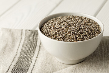 Bowl with raw chia seeds close up