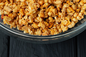 Bowl with granola on wooden table close up
