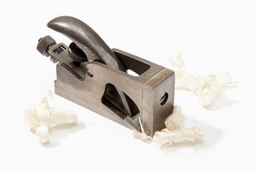 Old iron plane and wood shavings isolated on white background. Vintage carpenter tool