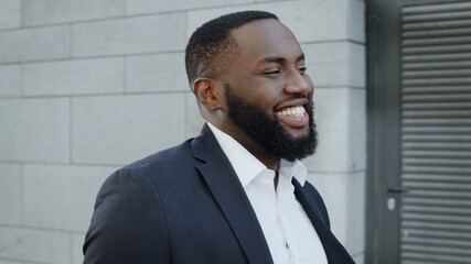 African businessman walking on city street. Smiling business man going outdoors