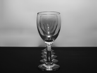 Row of empty wine glasses on table. Black and white concept