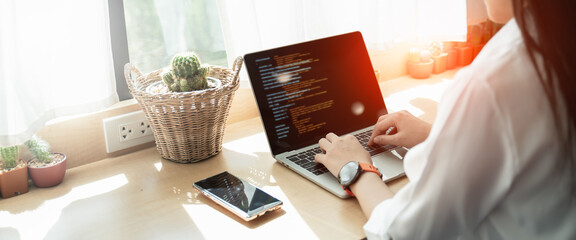 Back view of Programer Woman hands typing source code html and programming on screen...