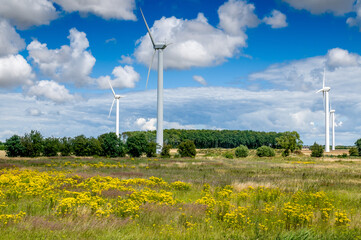 Alternative energy production concept. Wind turbines  against the backrop of a rural landscape