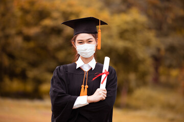 Graduated woman wear cap gown and  Medical mask for protection virus
