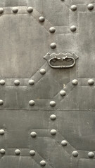 Vertical photo of metallic grey door elements. Dark forged iron material, specific grain on metal surface