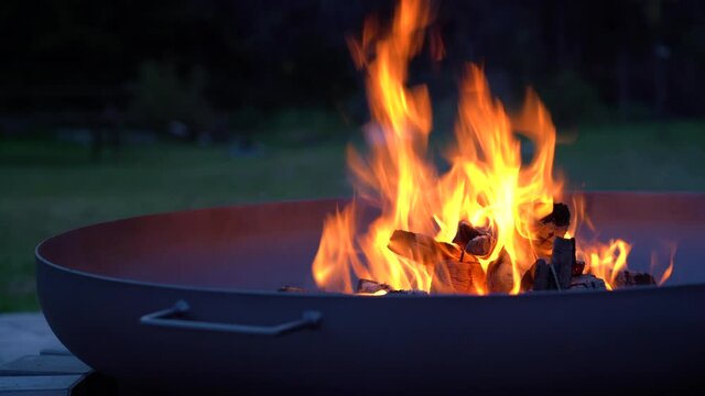 Iron fire pit and burning fire in a garden .  Campfire ,  close up image .