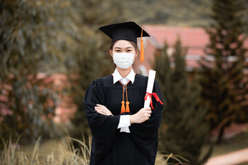 Graduated woman wear cap gown and  Medical mask for protection virus