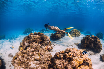Fototapeta na wymiar Woman dive underwater with yellow fins in tropical ocean.