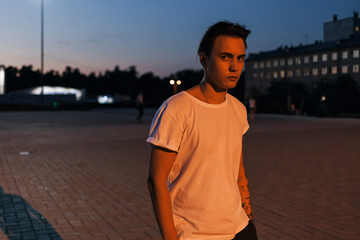 young man walking on the street evening